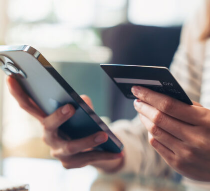 Woman hand holding credit cards and using smartphone for shopping online with payment on internet banking.