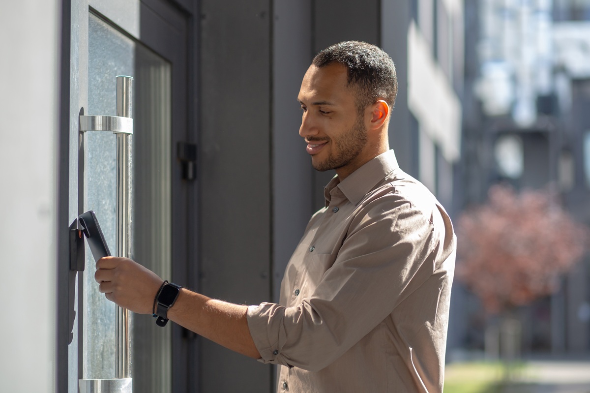 A man unlocking a smart lock with his phone.