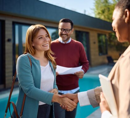 Real estate agent shaking hands with leads during a tour